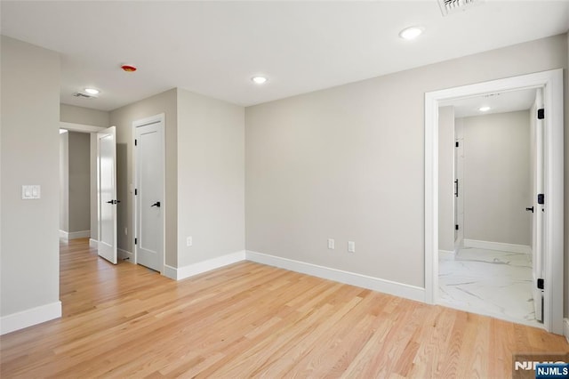 empty room with recessed lighting, marble finish floor, visible vents, and baseboards