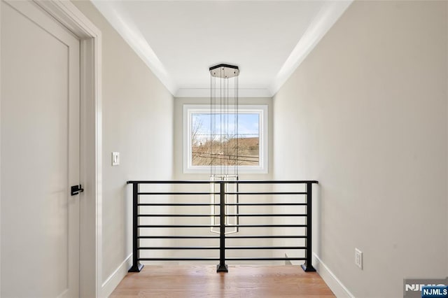 interior space featuring ornamental molding, wood finished floors, and baseboards