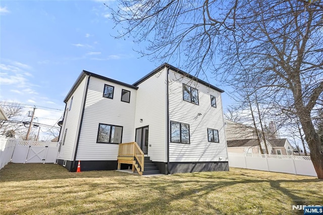 back of house featuring a lawn, a fenced backyard, and a gate