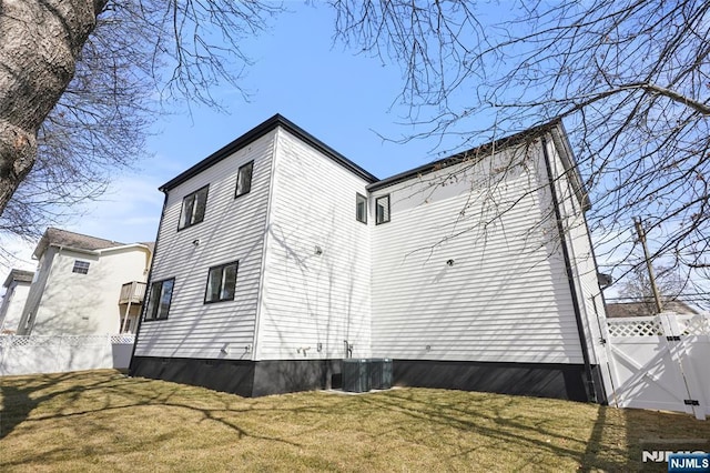 view of home's exterior featuring a yard, fence, a gate, and central air condition unit