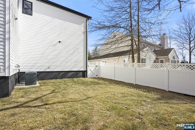 view of yard with fence and central AC