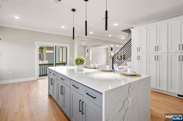 kitchen featuring hanging light fixtures, recessed lighting, a center island, and light wood-style floors