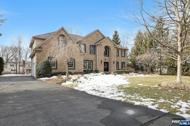 view of front of home featuring brick siding and a yard