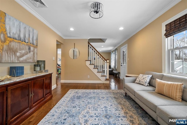 living room featuring dark wood-style flooring, visible vents, baseboards, ornamental molding, and stairway