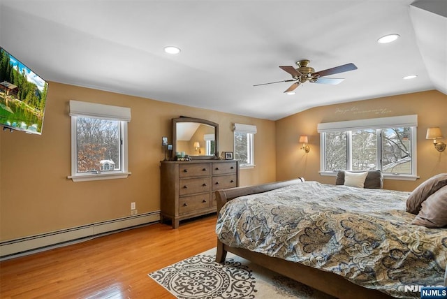 bedroom featuring a baseboard heating unit, multiple windows, vaulted ceiling, and wood finished floors