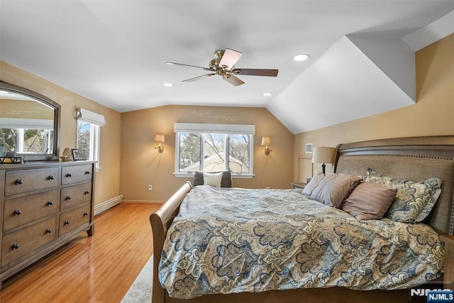 bedroom featuring light wood-style floors, a baseboard heating unit, multiple windows, and vaulted ceiling