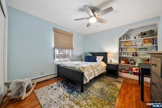 bedroom featuring ceiling fan, baseboard heating, and dark wood finished floors