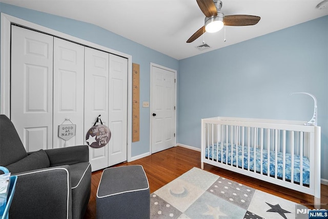 bedroom featuring wood finished floors, a ceiling fan, visible vents, baseboards, and a closet