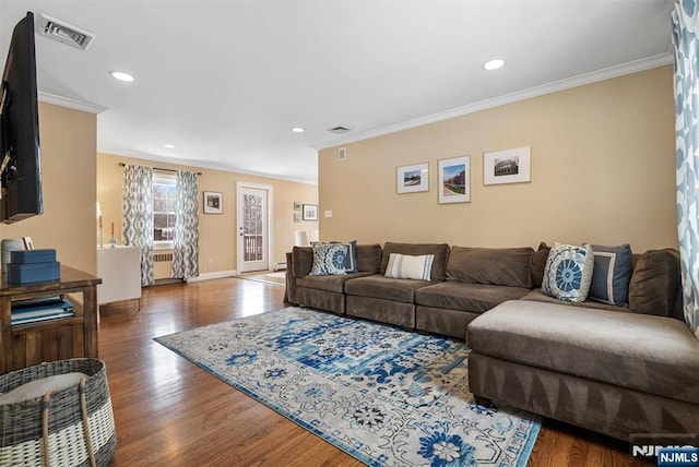 living area featuring dark wood-type flooring, recessed lighting, visible vents, and crown molding