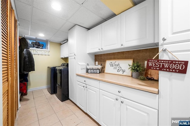 laundry room featuring light tile patterned flooring, recessed lighting, baseboards, washer and dryer, and cabinet space