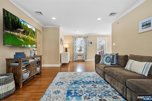 living room featuring visible vents, wood finished floors, and ornamental molding