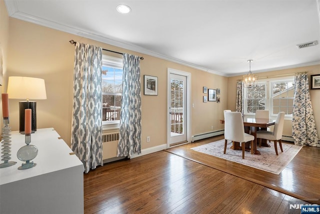 dining room with wood-type flooring, visible vents, crown molding, and baseboard heating