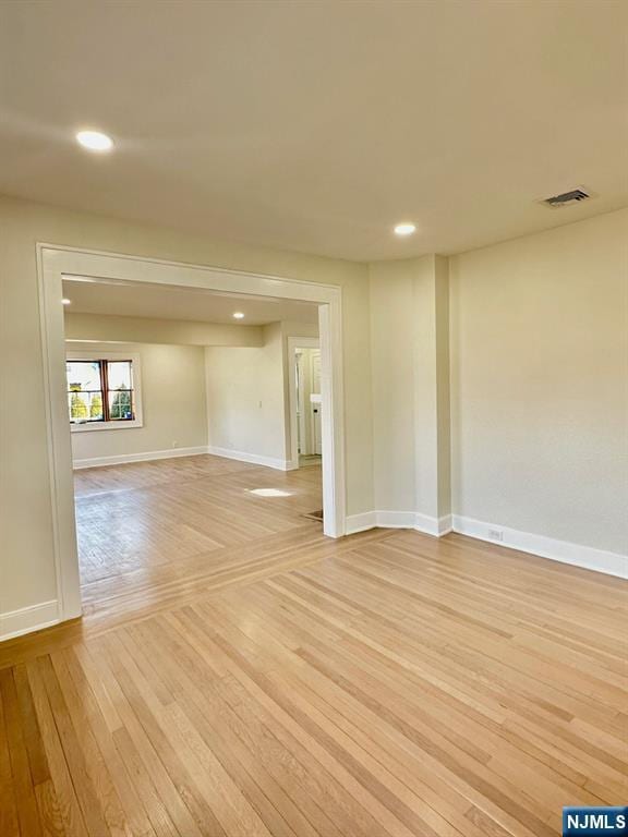 unfurnished room featuring light wood-style floors, visible vents, baseboards, and recessed lighting