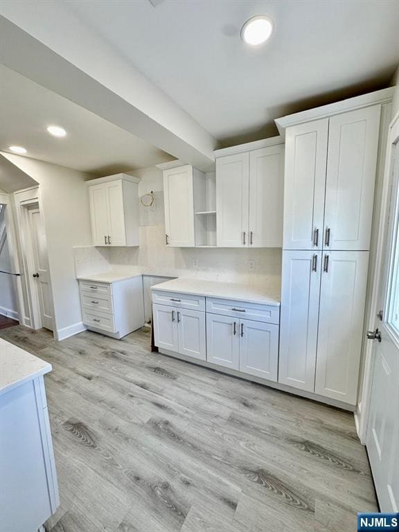 kitchen featuring light wood-type flooring, white cabinets, and open shelves