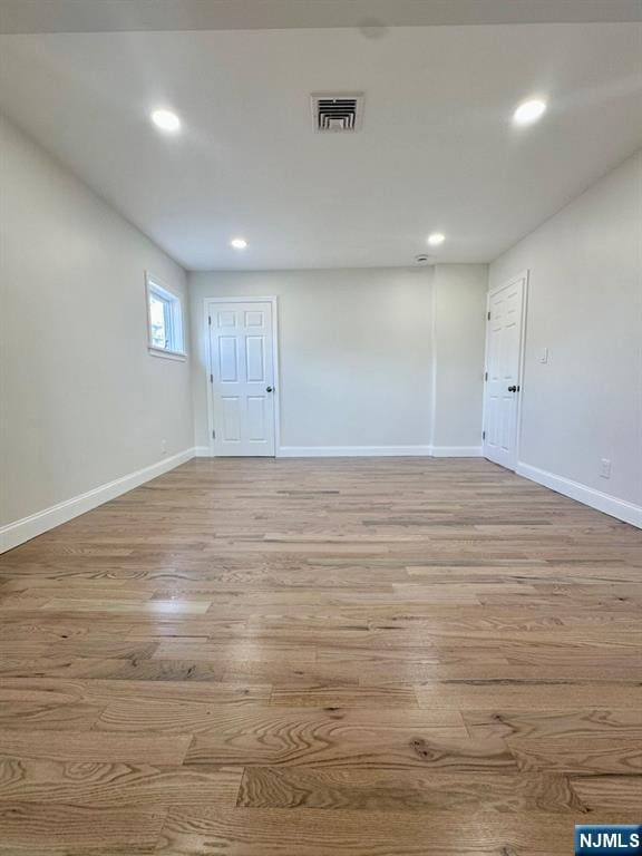 unfurnished room featuring light wood-type flooring, baseboards, and recessed lighting