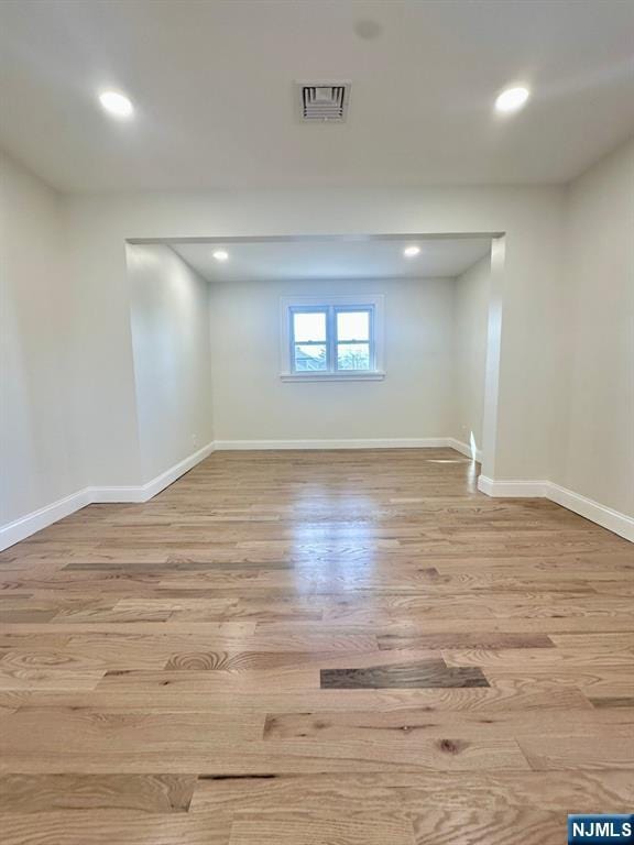 basement with light wood-style floors, recessed lighting, visible vents, and baseboards