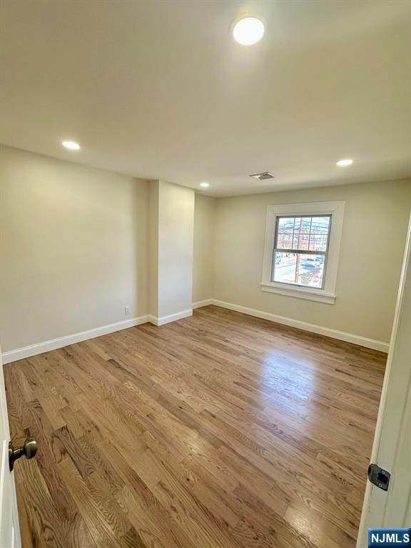 empty room with visible vents, recessed lighting, light wood-style flooring, and baseboards