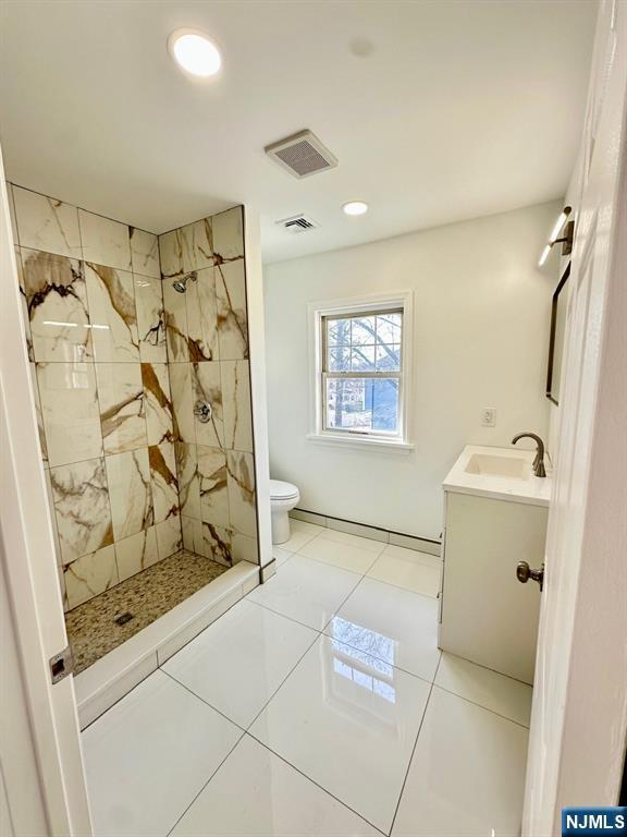 full bathroom featuring a stall shower, visible vents, and vanity