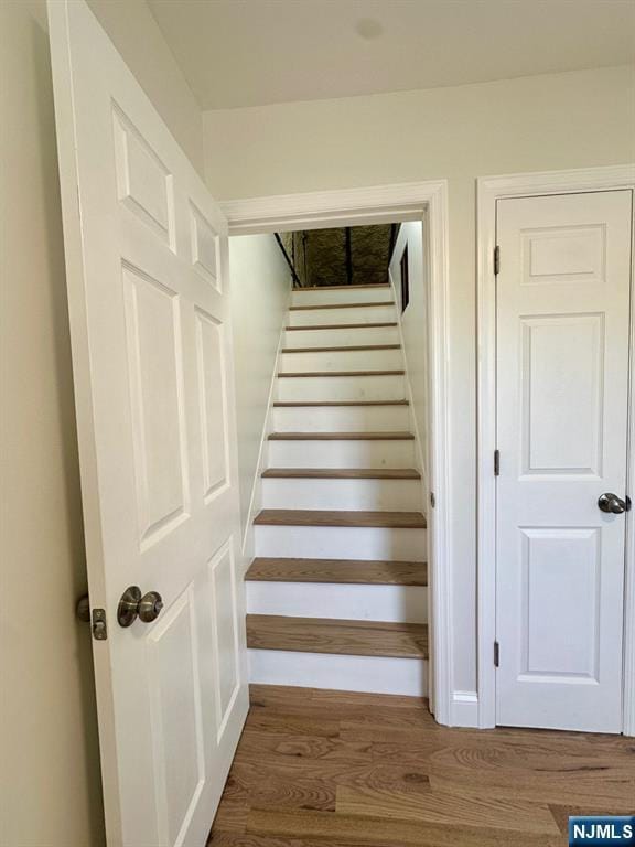 stairs featuring wood finished floors