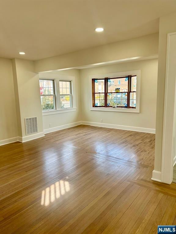 unfurnished room featuring recessed lighting, visible vents, baseboards, and wood finished floors