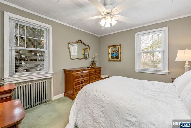 bedroom with carpet floors, radiator heating unit, baseboards, and crown molding