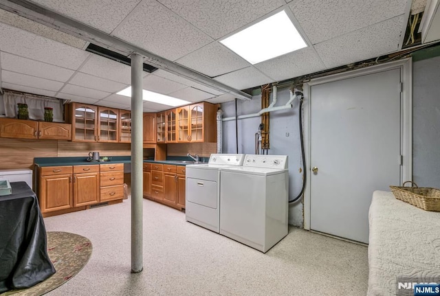 washroom with washer and clothes dryer, a sink, and cabinet space