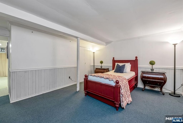 carpeted bedroom with a wainscoted wall