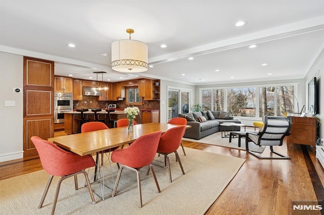 dining area featuring a healthy amount of sunlight, light wood finished floors, and recessed lighting