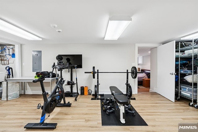 exercise area featuring light wood-style floors and electric panel