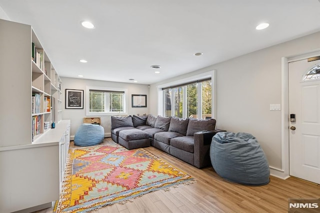 living room with light wood-style floors, baseboards, and recessed lighting