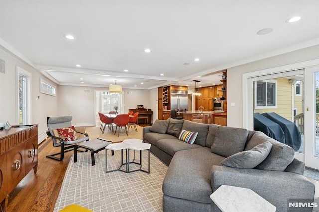 living area featuring light wood-style floors, baseboards, and recessed lighting