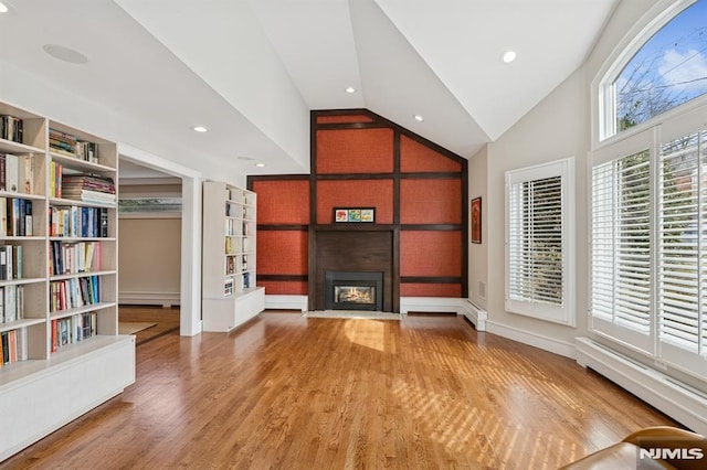 unfurnished living room with a fireplace, lofted ceiling, recessed lighting, baseboard heating, and wood finished floors