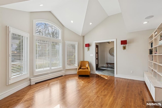 unfurnished room featuring a baseboard heating unit, recessed lighting, baseboards, and wood finished floors