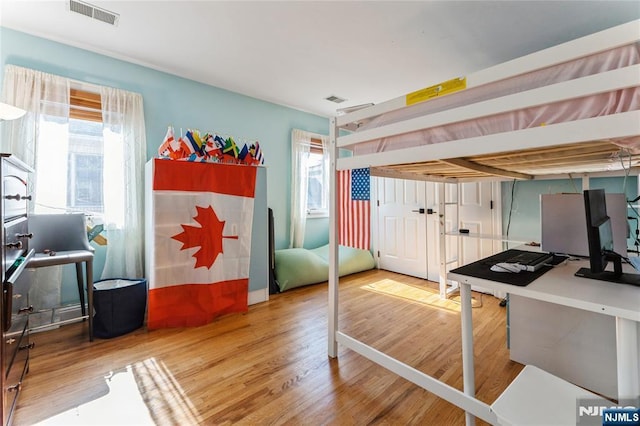 interior space featuring multiple windows, wood finished floors, and visible vents