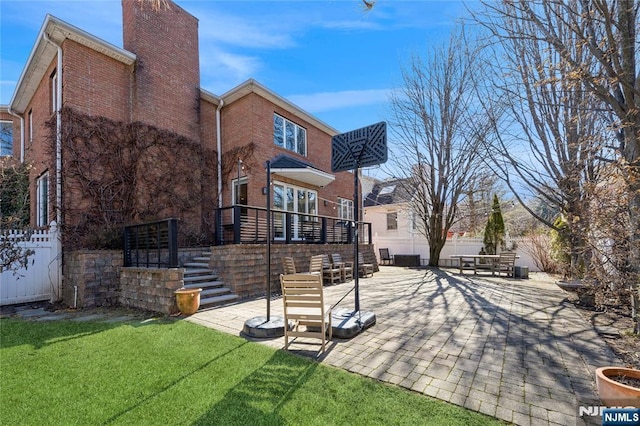 back of property featuring a patio area, brick siding, and a chimney