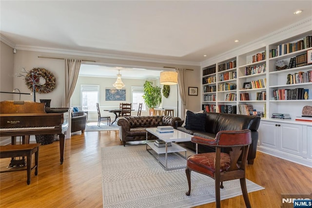 interior space with light wood-style flooring, built in shelves, and crown molding