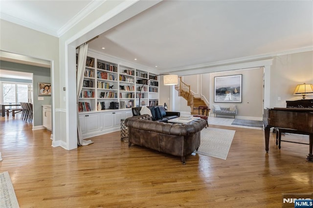 sitting room with ornamental molding, light wood-type flooring, stairway, and built in features