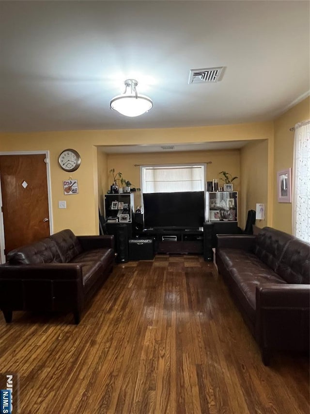 living room with dark wood-style floors and visible vents