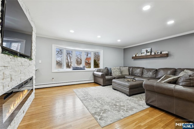 living room with ornamental molding, light wood-type flooring, a fireplace, and recessed lighting