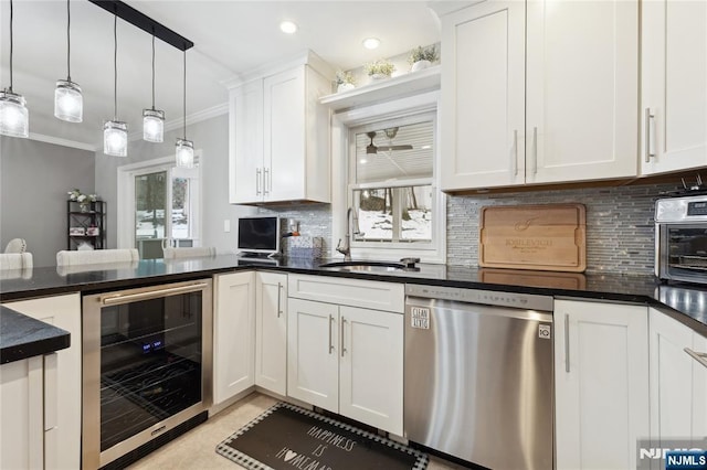 kitchen with dark countertops, wine cooler, white cabinets, and stainless steel dishwasher