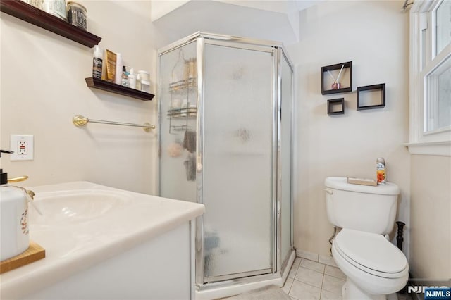 bathroom featuring toilet, tile patterned flooring, vanity, and a shower stall