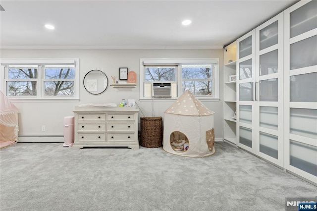 interior space with a baseboard heating unit, a healthy amount of sunlight, and light carpet