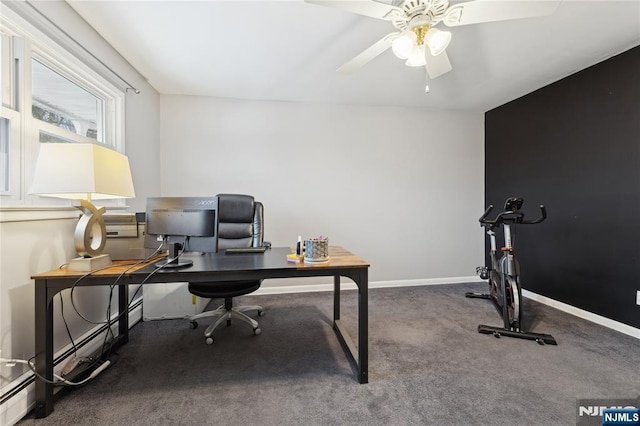 office with a ceiling fan, dark colored carpet, and baseboards