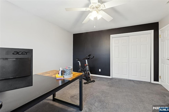 carpeted office with ceiling fan and baseboards