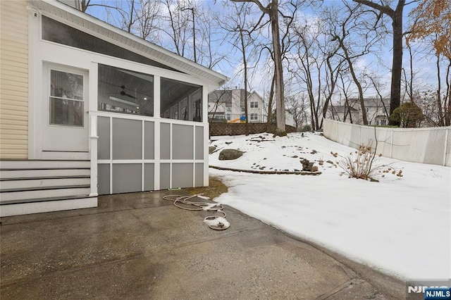 yard covered in snow with a sunroom