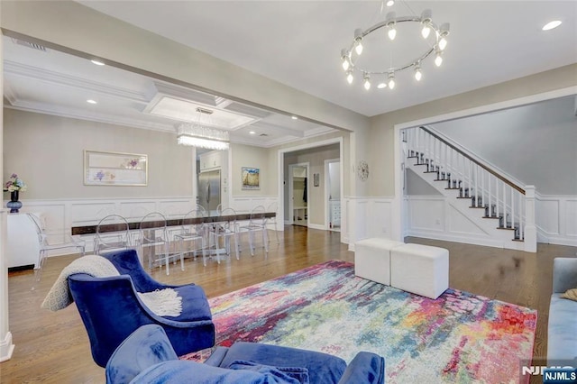 living room with recessed lighting, a decorative wall, wood finished floors, ornamental molding, and stairway