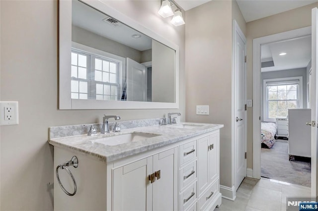 ensuite bathroom with tile patterned floors, visible vents, a sink, and double vanity