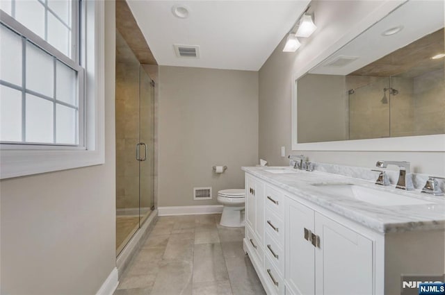 bathroom with a stall shower, a sink, visible vents, and baseboards