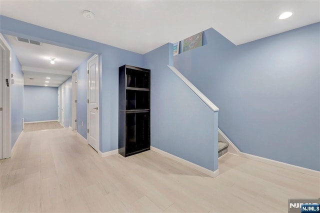 corridor featuring stairs, wood finished floors, visible vents, and baseboards