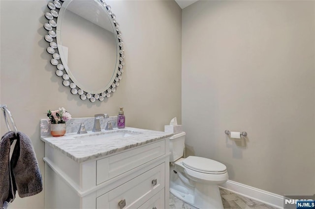 bathroom with toilet, marble finish floor, baseboards, and vanity